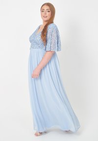 Ljusblå lång klänning med paljetter på bodicen och korta fjärilärmar, med en svävande kjol och mjuk textur.