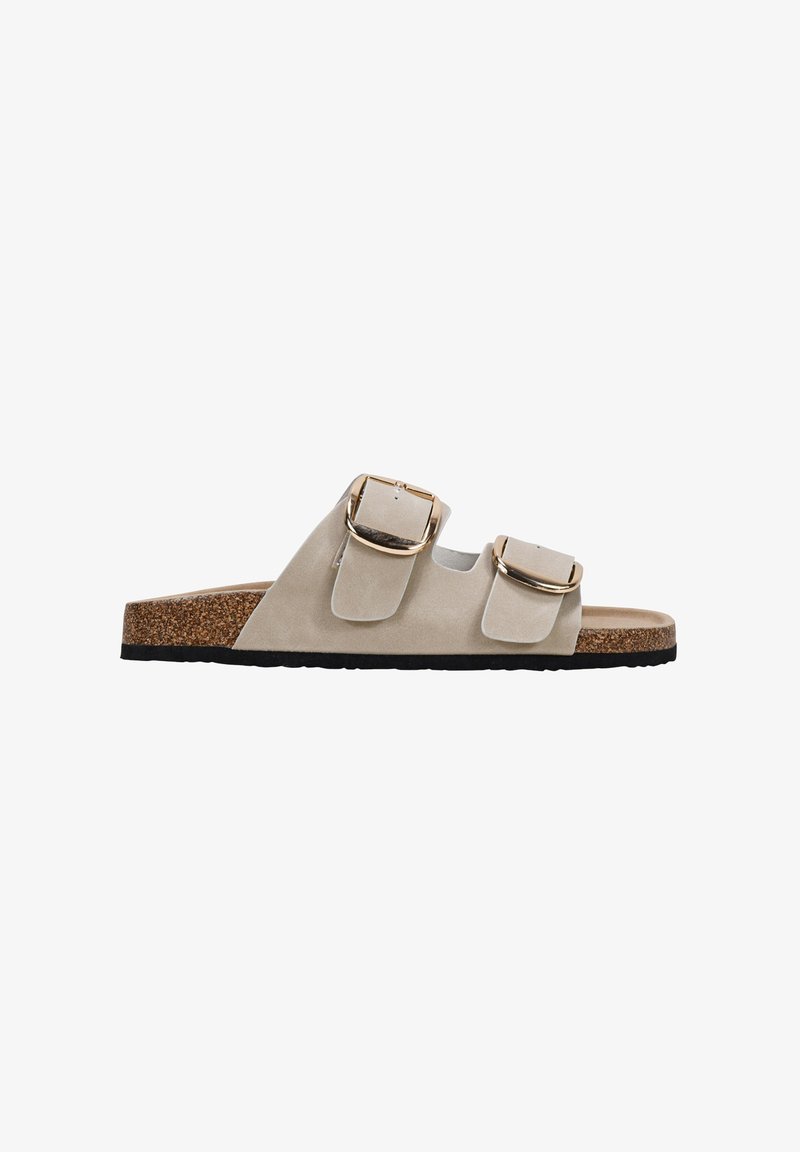 Beige suede slide sandal with two adjustable buckle straps, cork footbed, and black rubber outsole. Flat design with minimalistic accents.
