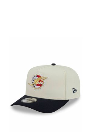 Casquette de baseball beige et noire avec un logo dauphin doré au-dessus d'un emblème du drapeau américain sur le panneau avant et le logo New Era sur le côté.