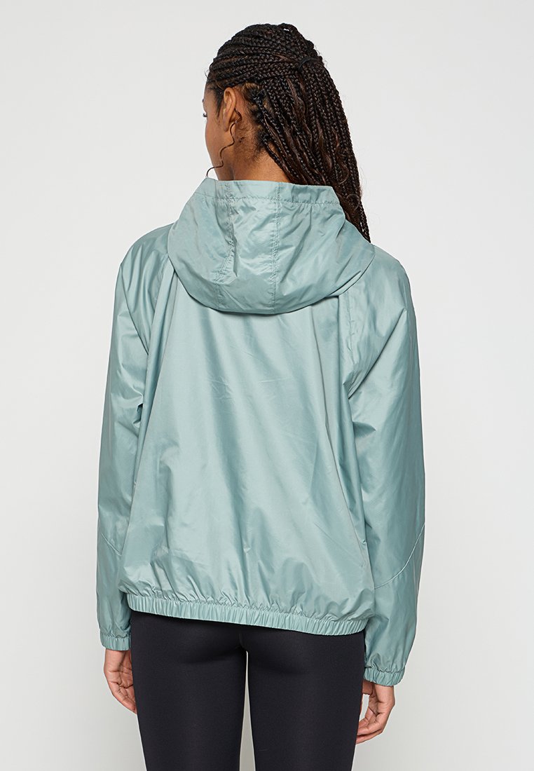 Helle blaue, kapuzenjacke mit tailliertem Schnitt. Glattes, glänzendes Material mit lässiger Passform. Elastische Bündchen und Saum, minimalistische Details.