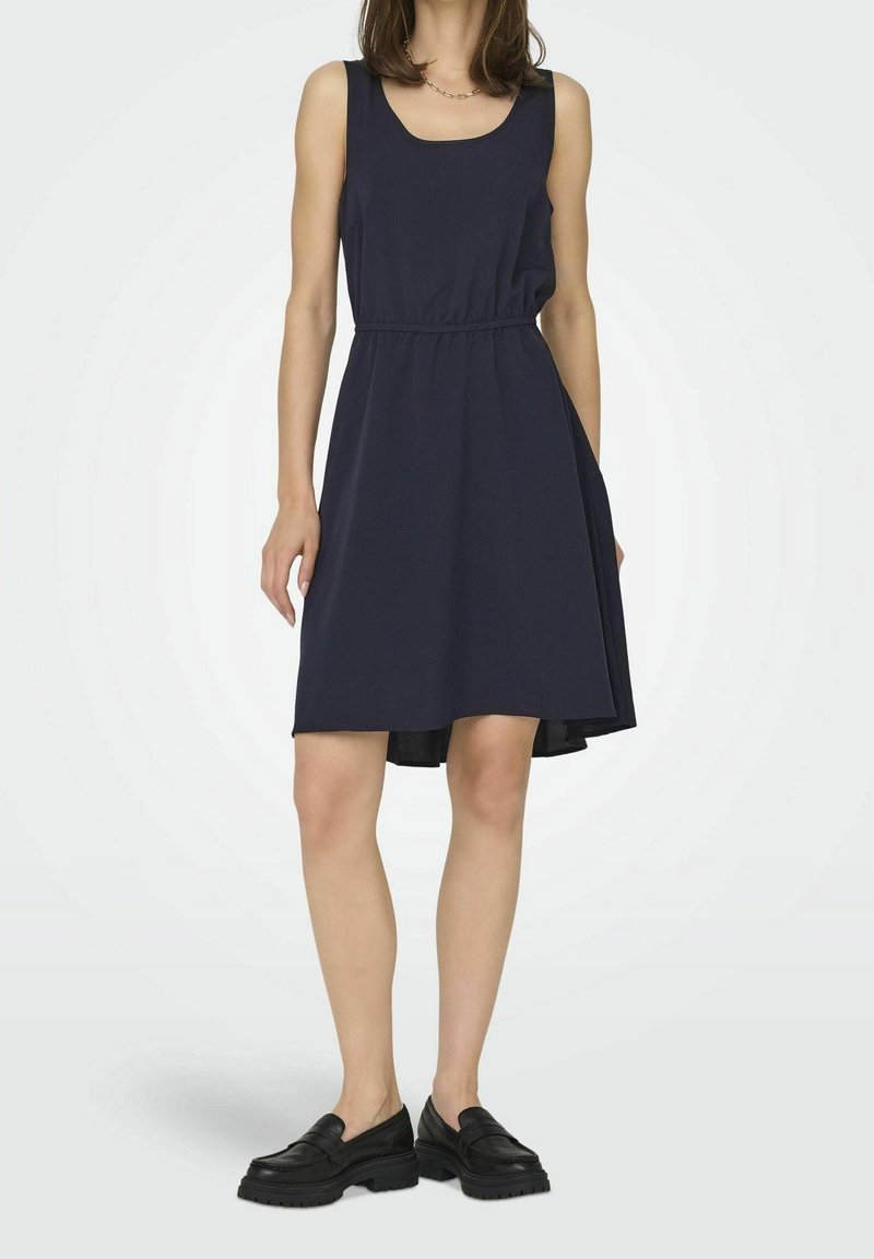 Robe sans manches marine avec un décolleté arrondi, une taille élastique et une silhouette en A ; tissu lisse avec un ourlet qui tombe juste au-dessus des genoux.