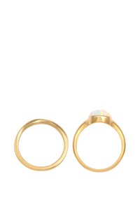Guldring set som innehåller en slät bandring och en andra ring med en polerad opal ädelsten som visar iriserande färger.