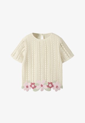 Haut en maille crème à manches courtes avec un motif ajouré vertical et des fleurs au crochet roses et rouges avec des feuilles vertes le long de l'ourlet.