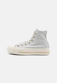 Jasnoszare sneakersy typu high-top wykonane z płótna. Posiadają złote oczka, białą gumową podeszwę i minimalistyczne detale w szwach.