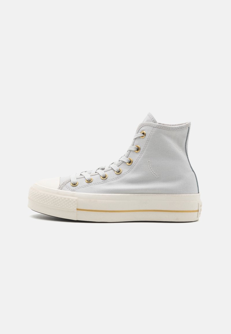 Jasnoszare sneakersy typu high-top wykonane z płótna. Posiadają złote oczka, białą gumową podeszwę i minimalistyczne detale w szwach.