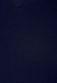 Marinblå stickad tröja med V-ringning, slät textur och konsekvent ribbning i hela tyget.