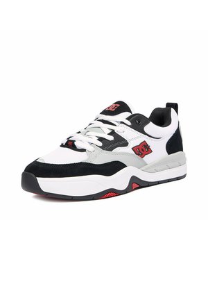 Weißer und schwarzer Sportschuh mit rotem DC-Logo, weißen Schnürsenkeln und dicker Sohle mit roten und schwarzen Profil-Details, von der Seite betrachtet.