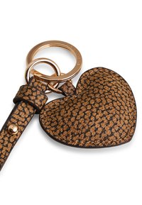 Porte-clé en forme de cœur fabriqué dans un matériau brun texturé avec un motif léopard, doté d'un anneau en métal doré et d'une sangle en simili cuir.