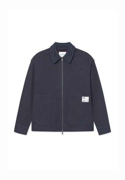 Navyblauwe jas met een frontrits, patchzakken en een klein label op de linkerzak, met een gestructureerde kraag en gladde stof.
