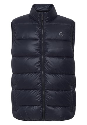 Pufferska prsluk tamnoplave boje s visokim ovratnikom, zatvaranjem na zip sprijeda i bočnim džepovima. Glatka tekstura s kvadratićastim dijelovima i detaljem s logotipom.