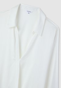 Camicia bianca a maniche lunghe con colletto classico, taglia 2XL, etichetta del marchio "Terranova" visibile all'interno dello scollo.