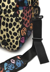 Črn in bež nahrbtnik z okrasnim leopardjim potiskom, barvitimi abstraktnimi vzorci in snemljivim črnim trak z zaponko za pribor.