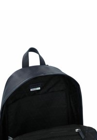 Zaino nero con un esterno testurizzato e una finitura liscia. L'interno è foderato in tessuto nero e presenta una tasca con zip.