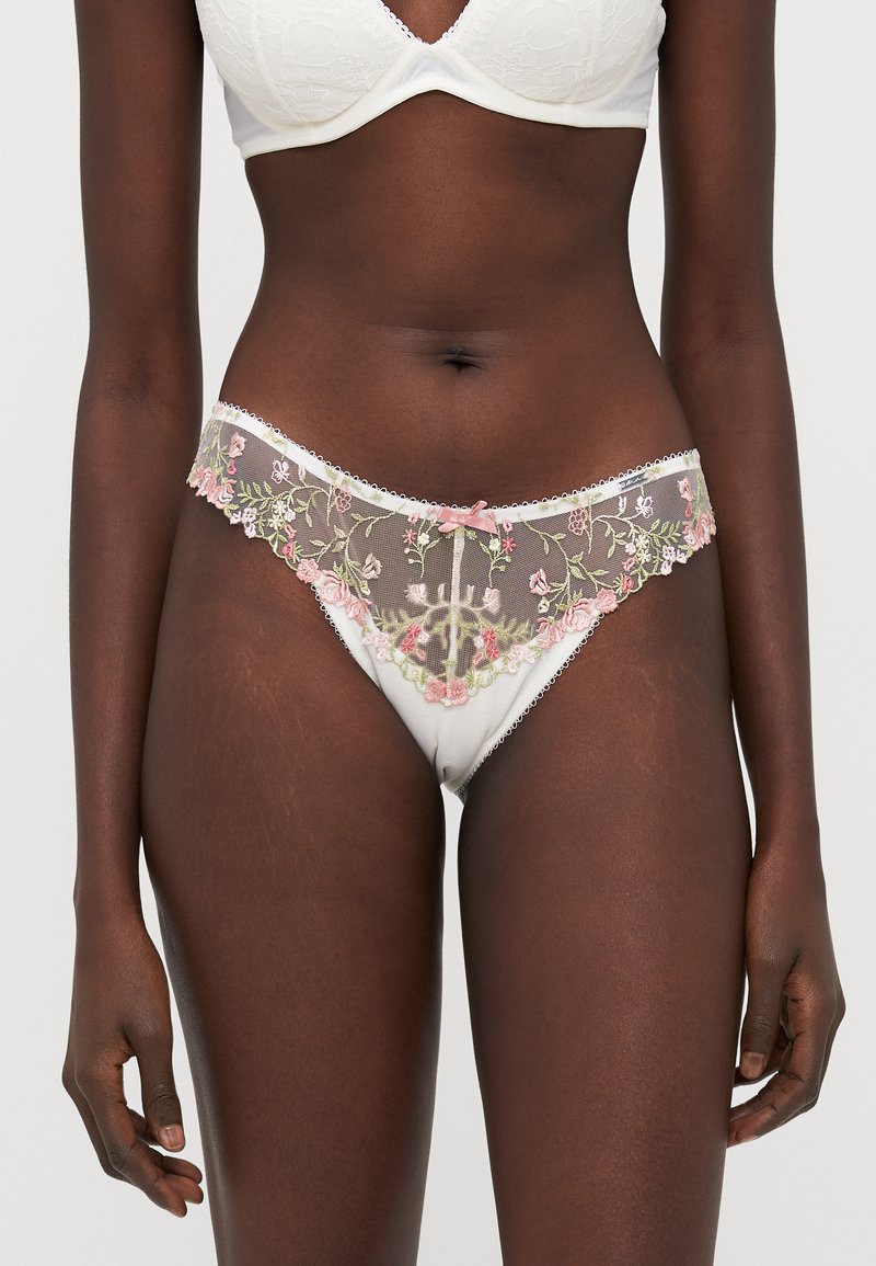 Hvit undertøy med blomsterbroderi i rosa og grønt, med et gjennomsiktig lace frontpanel og bølgete kanter. Glatt stoff på baksiden.