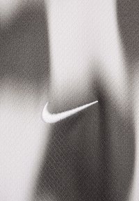 Grijs en wit sportstof met een subtiel verloopontwerp. Een witte geborduurde Nike-logo is zichtbaar. De textuur lijkt zacht en ademend.