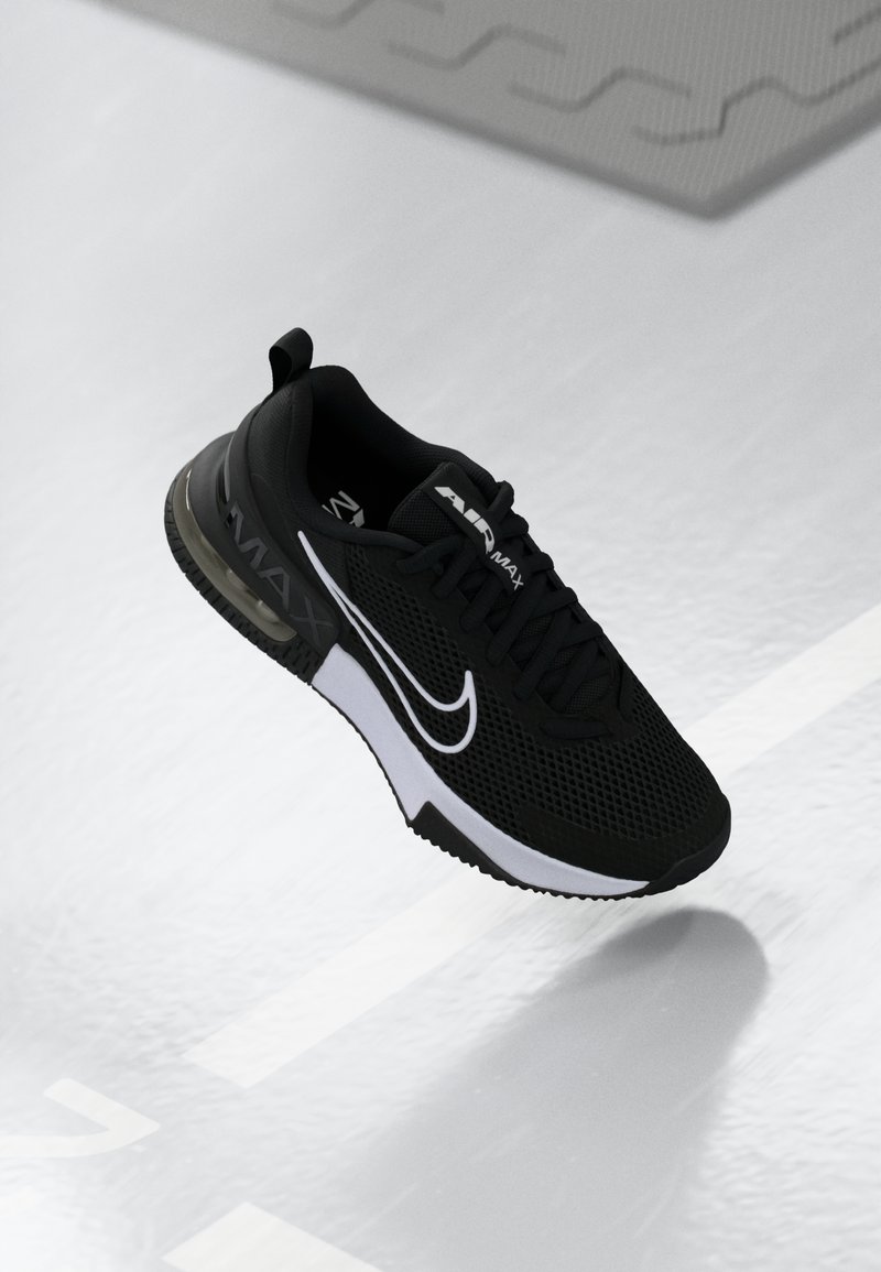 Crne atletske tenisice s mrežastim gornjim dijelom, bijelim naglascima, vidljivom Air Max amortizacijom i teksturiranom potplatom. Šnire i logo prisutni.