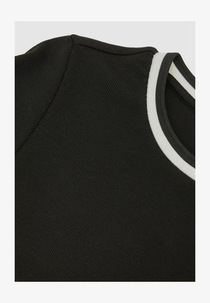 Čierna rebrovaná látka s okrúhlym výstrihom ozdobeným bielymi a sivými pruhmi. Zameriava sa na textúru a farebné detaily.