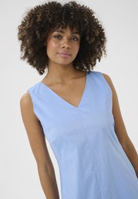 Light blue sleeveless dress with a V-neck, smooth texture, and a simple design. Features a single front seam and no visible embellishments.