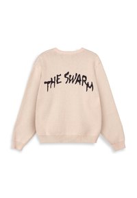Beige gebreide sweater met lange mouwen en ribbels aan de manchetten en onderkant, met daarop de tekst "THE SWARM" in vet, onregelmatig zwart lettertype op de rug.