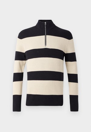 Czarna i beżowa swetrowa bluzka w paski, o prążkowanej strukturze, z długimi rękawami oraz krótkim srebrnym zamkiem błyskawicznym przy wysokim kołnierzu.