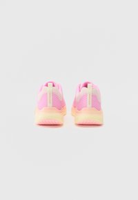 Zapatillas deportivas rosas con una parte superior de malla texturizada, cuello acolchado y una suela transparente suave que presenta un degradado amarillo y acentos en rosa claro.