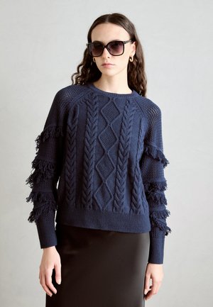 Maglione lavorato a maglia blu navy con motivi a treccia e dettagli frangiati sulle maniche. I polsini e l'orlo a coste completano il design.