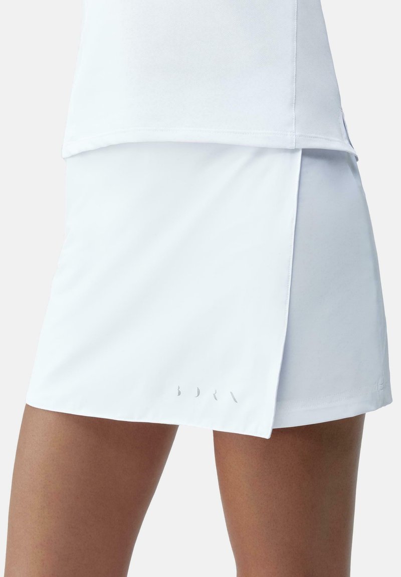 Falda atlética blanca con un diseño en capas y un sutil corte lateral. Confeccionada en un material ligero y elástico; presenta un branding mínimo.