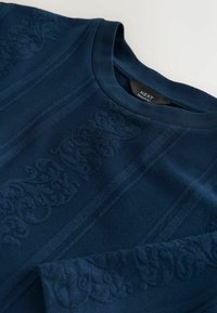 Marineblauer Pullover mit Rundhalsausschnitt und strukturierten floralen sowie vertikalen Streifenmustern, beschriftet mit "NEXT Regular Fit."