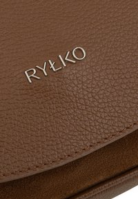 Borsa in pelle marrone con texture, con accenti lisci, caratterizzata dal logo del marchio "RYŁKO" in metallo argentato, evidenziato sulla parte anteriore.