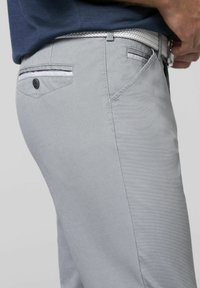 Hellgraue Chinos aus strukturiertem Stoff, mit Knopf- und Fake-Taschenakzenten sowie einem geflochtenen weißen Gürtel, seitlich dargestellt.
