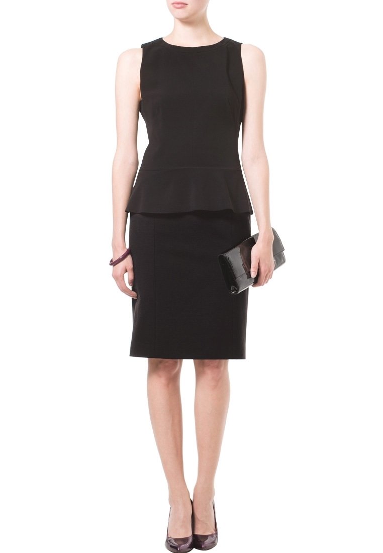 Robe peplum noire avec une jupe ajustée, tissu texturé, col rond et sans manches. Accompagnée d'une pochette noire.