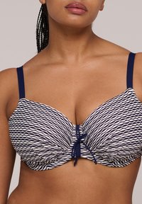 Wielokolorowy biustonosz bikini w granatowo-białe paski, z marszczonym środkiem, szerokimi ramiączkami i dekoracyjnym wiązaniem z przodu. Gładka tekstura tkaniny.