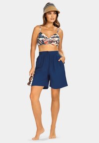 Wielokolorowy bikini w kwiaty z skręconym środkiem, zestawiony z granatowymi, plisowanymi szortami z detalem w postaci guzika i kieszeniami.