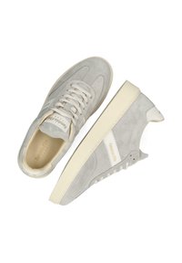 Lichtgrijze suède sneakers met witte accenten, ronde neus, platte zool en beige veters. Heeft een merklogo op de tong en zijkant.