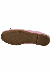 Chaussure en daim rose avec une semelle en caoutchouc beige plate, arborant un motif texturé pour l'adhérence. Pas de marque visible en dessous.