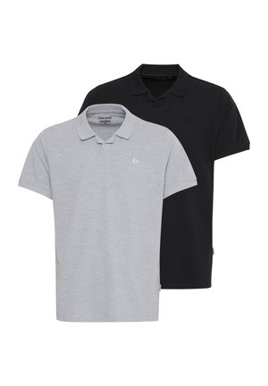 Dos camisetas polo: una de color gris claro con un logo sutil y la otra negra. Ambas tienen un cuello clásico y mangas cortas, confeccionadas con una mezcla de algodón.