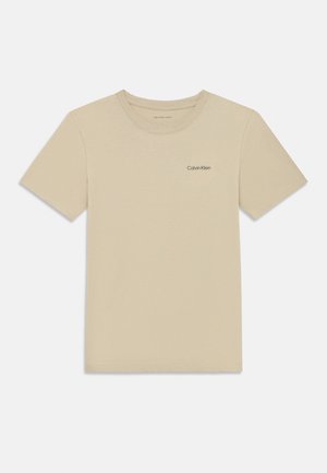 T-shirt de algodão bege com decote arredondado, mangas curtas e um discreto logotipo da Calvin Klein impresso na área do peito esquerdo.