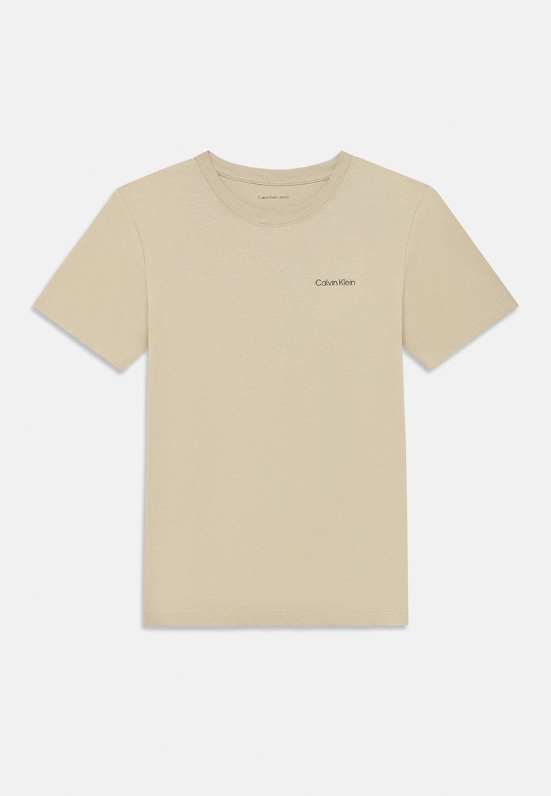Bežové bavlnené tričko s okrúhlym výstrihom, krátkymi rukávmi a decentným logom Calvin Klein potlačeným na ľavej strane hrude.