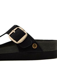 Sandales noires avec une semelle texturée, dotées d'une boucle dorée et d'un accent circulaire. Fabriquées en matériau doux avec un design plat.