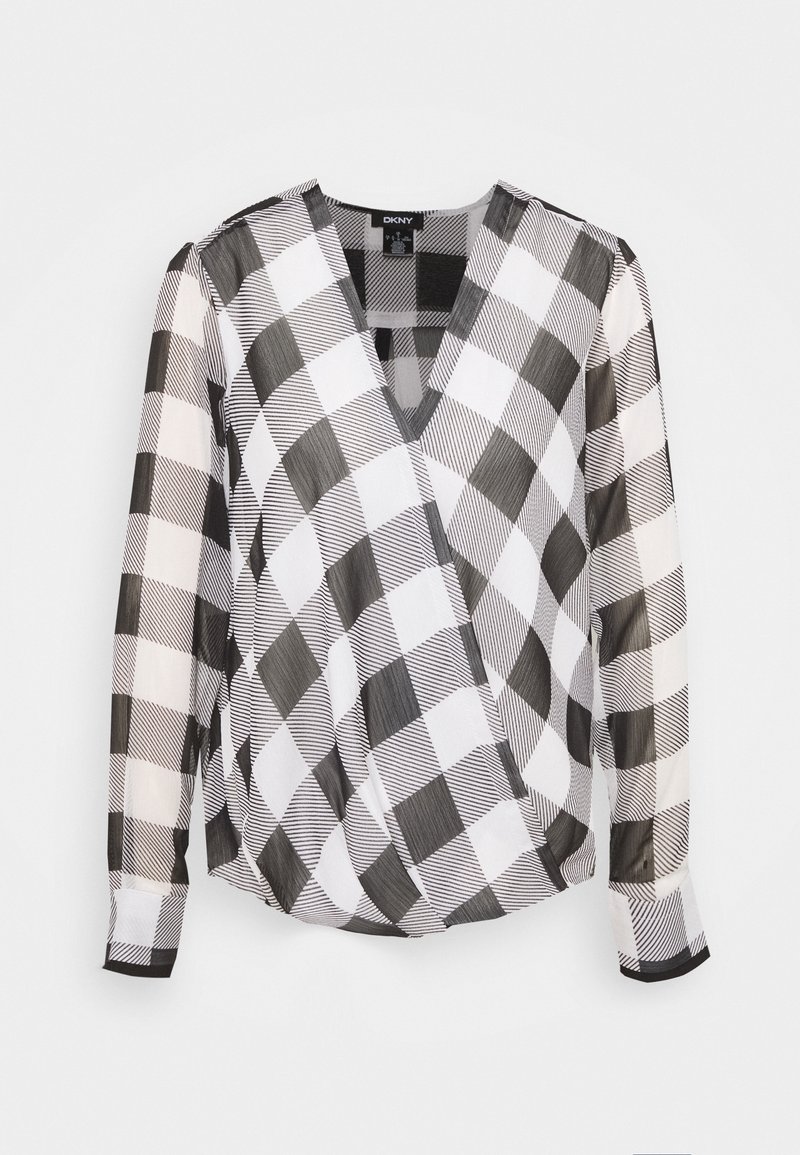 Blouse femme à manches longues avec grand motif à carreaux noir et blanc et design avant à col en V profond avec chevauchement.