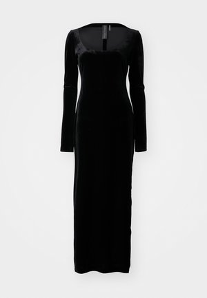 Robe en velours noir à manches longues avec un décolleté carré et une silhouette près du corps, présentant une texture lisse et un design long jusqu'au sol.