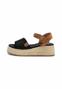 Sandalias de tela negra trenzada con una correa de ante marrón en el tobillo, plataforma de esparto trenzada y suela de goma texturizada.