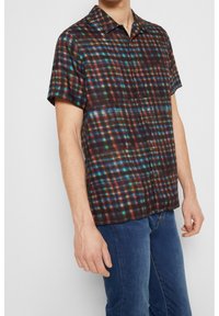 Camicia a maniche corte con bottoni in tessuto leggero e scuro, caratterizzata da un motivo a quadri multicolore, colletto alla moda e vestibilità rilassata.