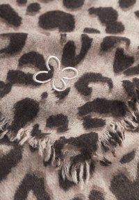 Sciarpa con stampa leopardata in morbido tessuto, caratterizzata da tonalità di beige e marrone scuro, con un dettaglio di fiore ricamato e bordi sfrangiati.