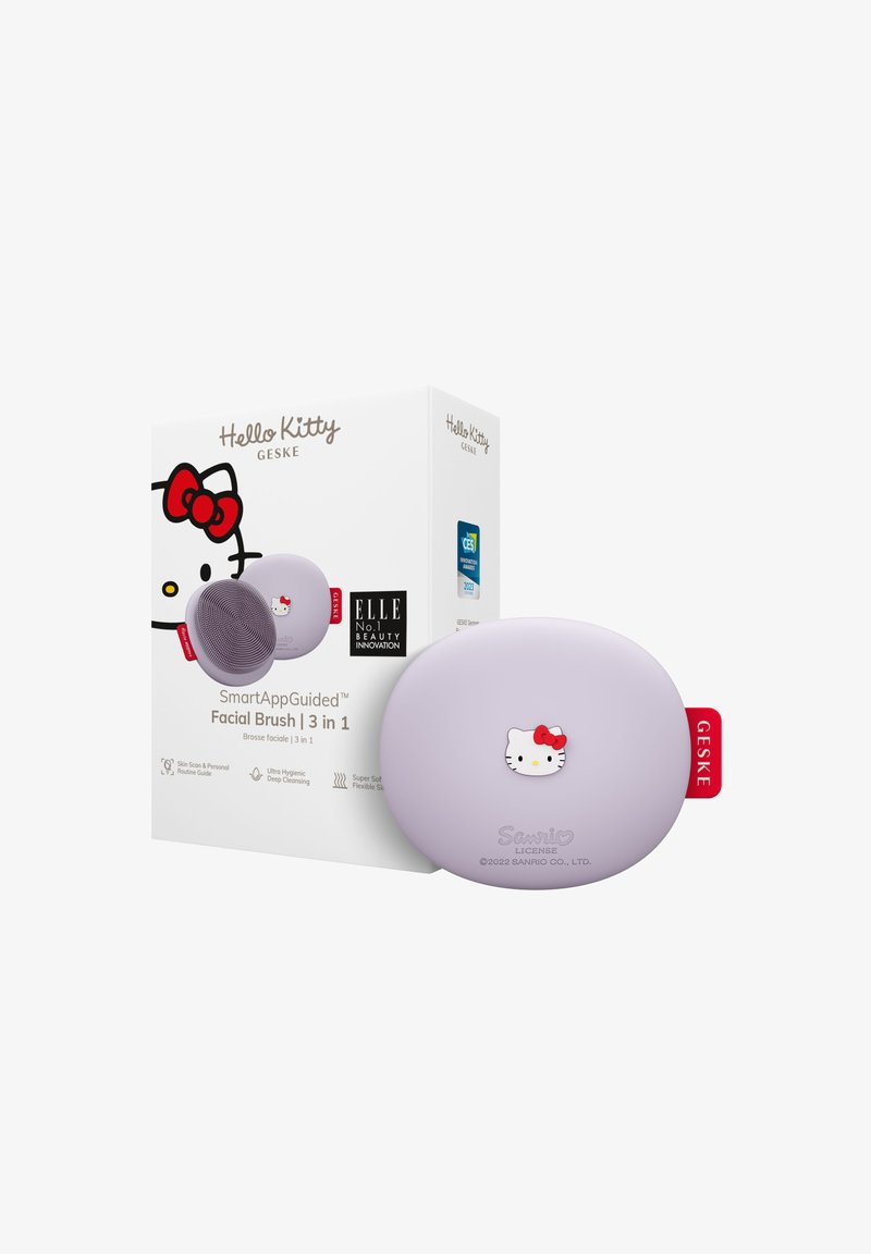 Hello Kitty ansigtsbørste i lyse lilla, med en blød silikoneoverflade og et tegneseriefigurb design. Æsken indeholder produktdetaljer og logoer.