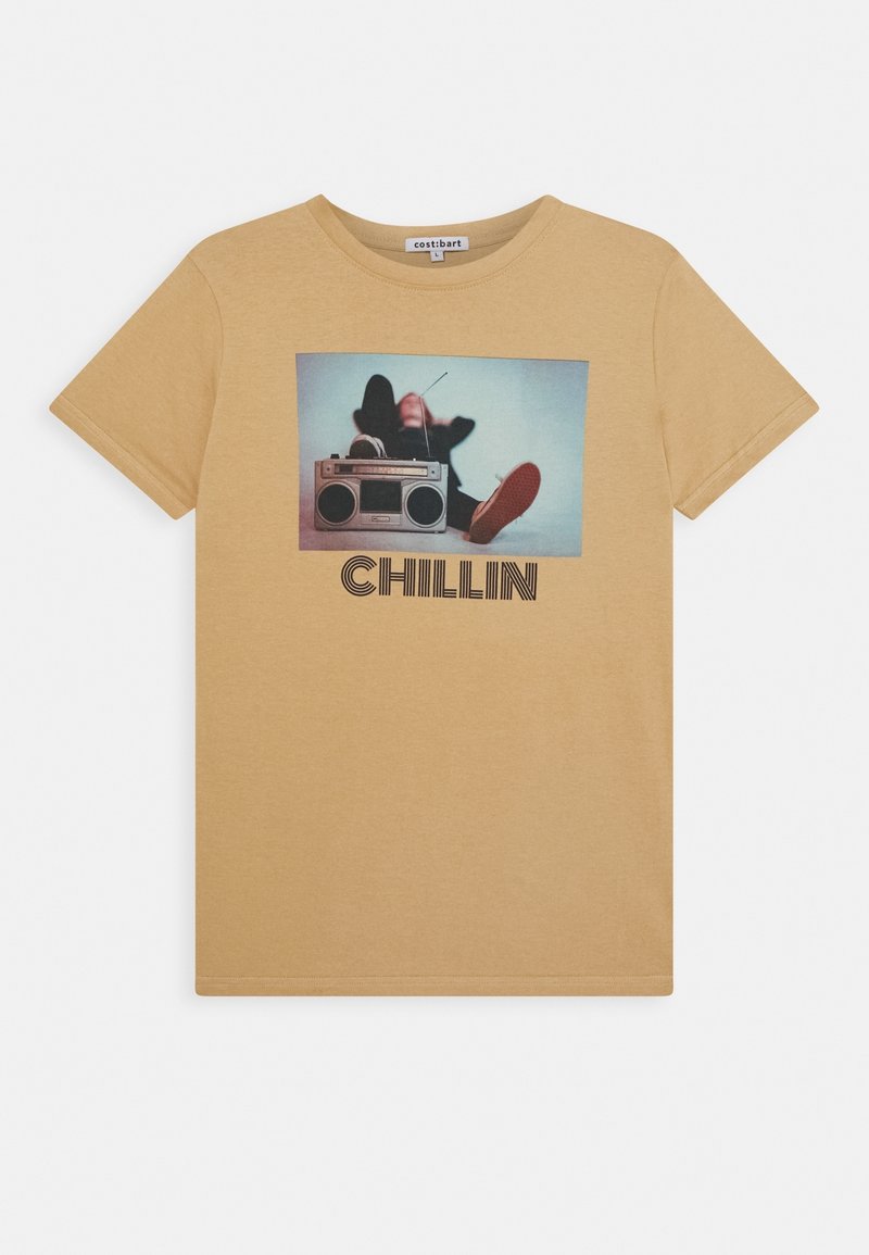 T-shirt beige avec un graphisme d'une personne allongée derrière un boombox et le mot «CHILLIN» sous l'image.