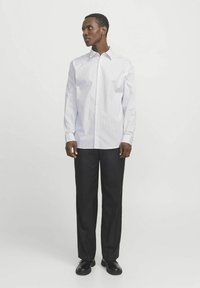 White long-sleeve shirt with thin blue stripes, button-down collar, paired with black trousers and black shoes. Simple design, no patterns.
