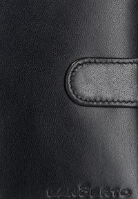 Czarny portfel ze skóry z teksturowanym wykończeniem, gładkimi akcentami i zapięciem na zatrzask. Nazwa marki jest wytłoczona na dole.