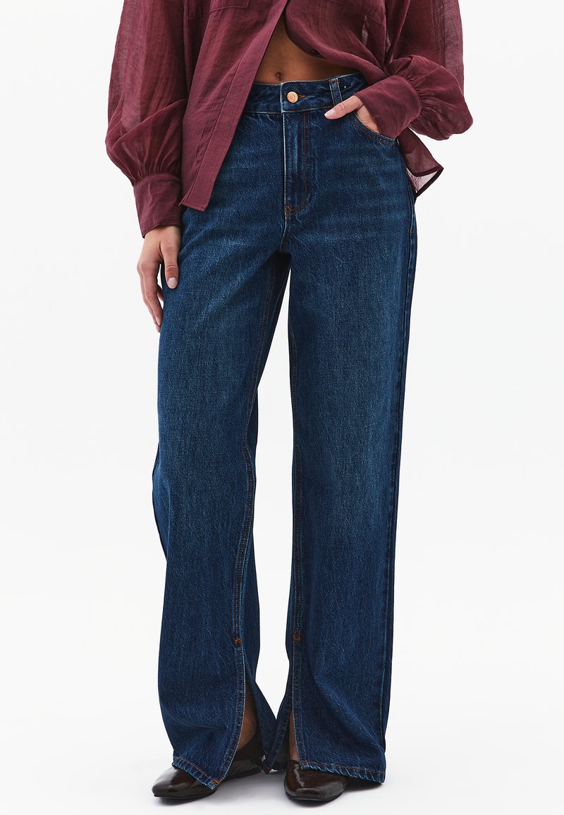 Breda ben mörkblå denimjeans med hög midja, med en framsida med knappknäppning och detaljer på sidorna med slitsar.