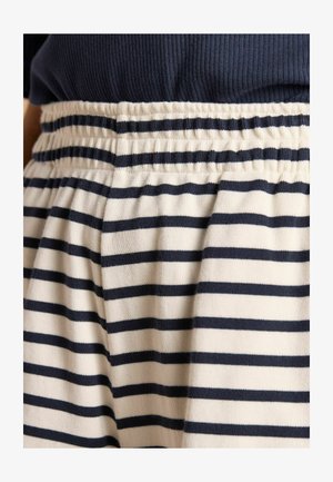 Stribede shorts med hvid bund og marineblå striber, med en elastisk talje med rynker og blødt, tekstureret stof.